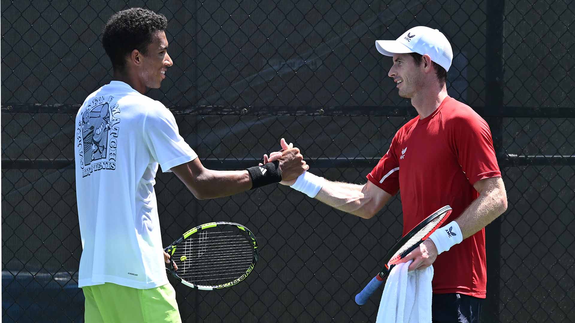 Felix Auger-Aliassime y Andy Murray se dan la mano tras entrenar juntos el sábado en Washington.