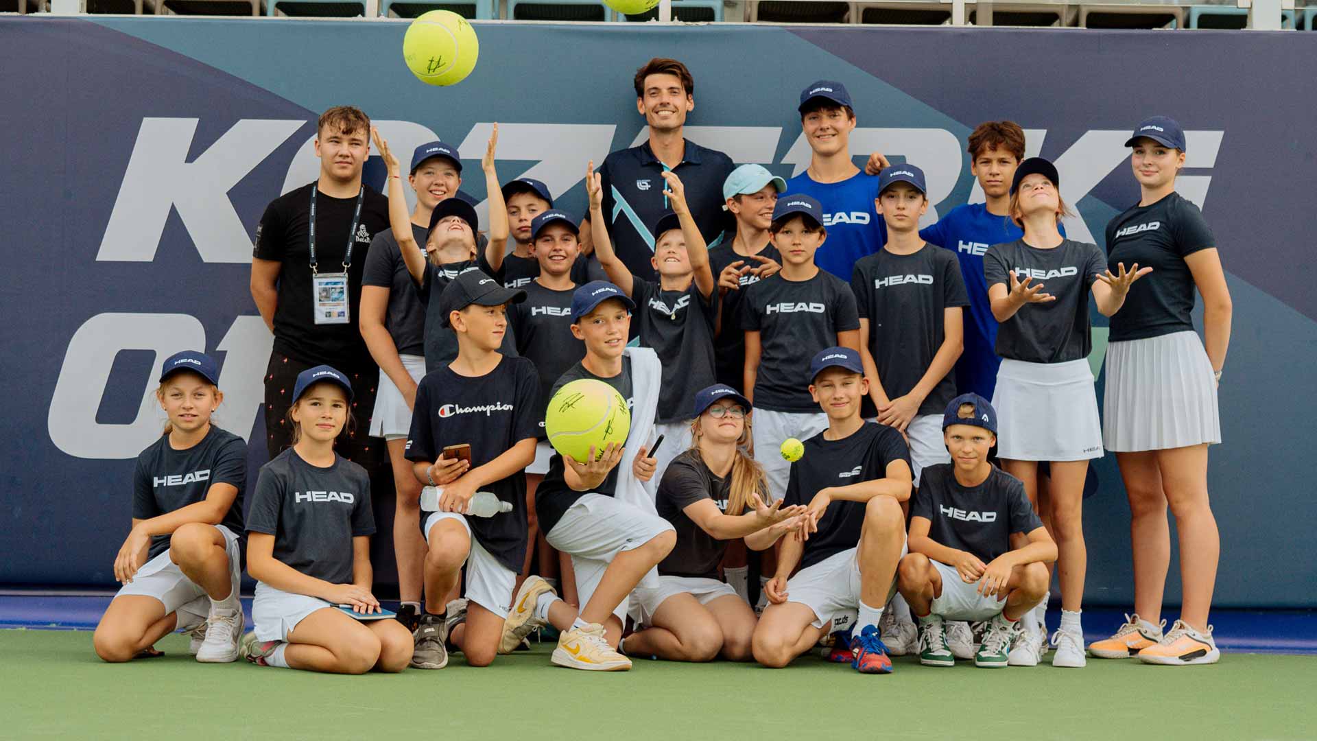 <a href='https://wwwx.atptour.com/en/players/marc-andrea-huesler/hh06/overview'>Marc-Andrea Huesler</a> poses with the Grodzisk Mazowiecki ballkids affter the trophy ceremony.